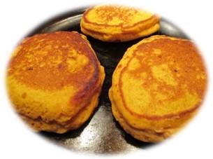 three pumpkin flapjacks in cast iron fry pan.
