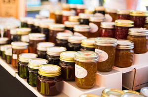 Close up image of 25 jars of jam at a Farmers Market table