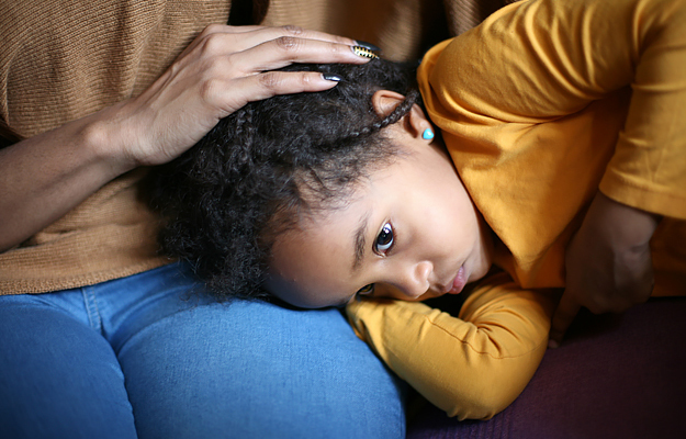 A young child with an earache being comforted by her mother.