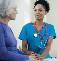 Image of an older woman and a health professional in a clinical setting. 