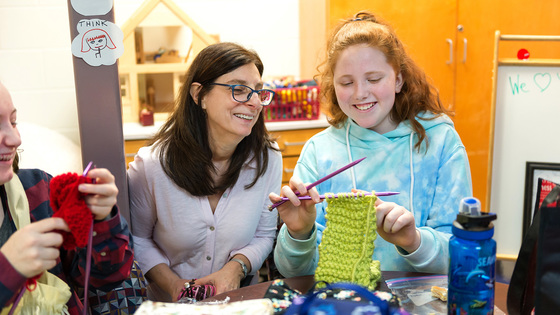 Student and teacher knitting